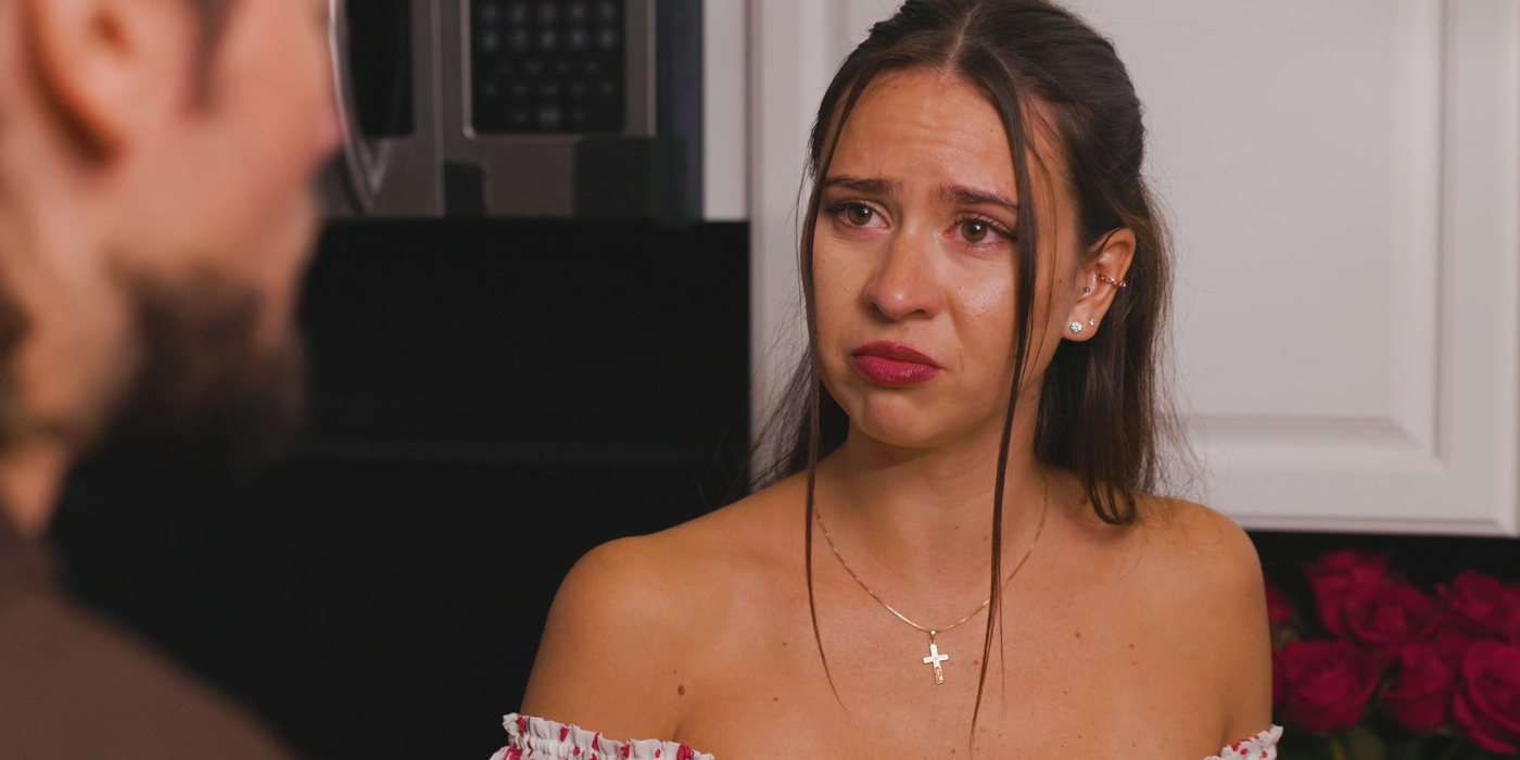 Film still: in tears, facing her partner in a kitchen