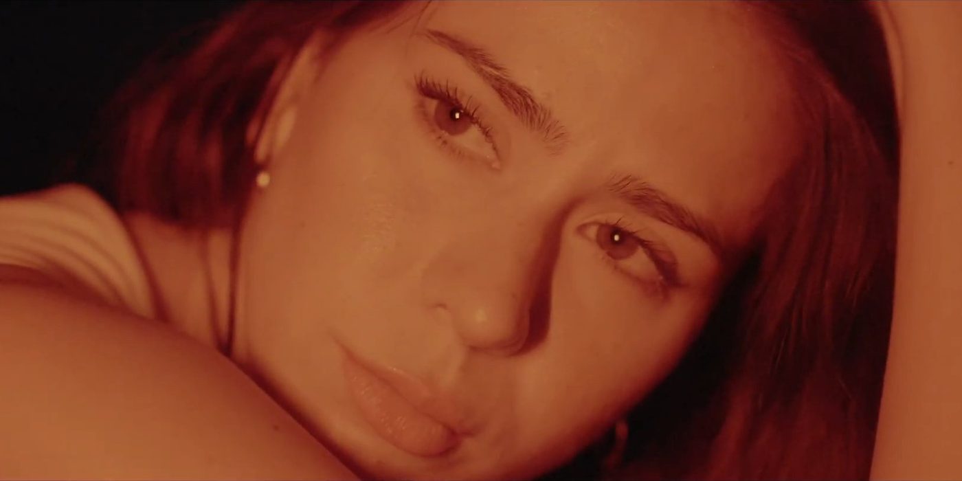 Film still: warm close-up, resting her head on her arm