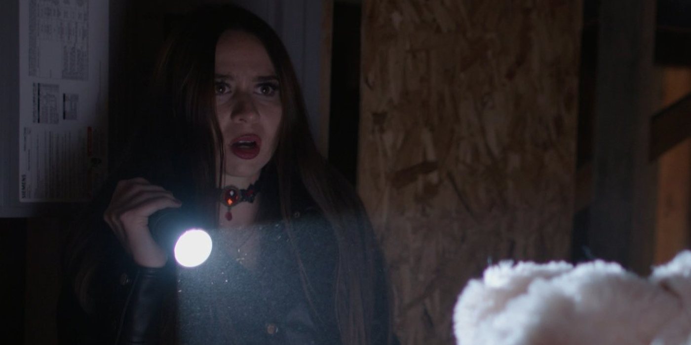 Film still: holding a flashlight, frightened