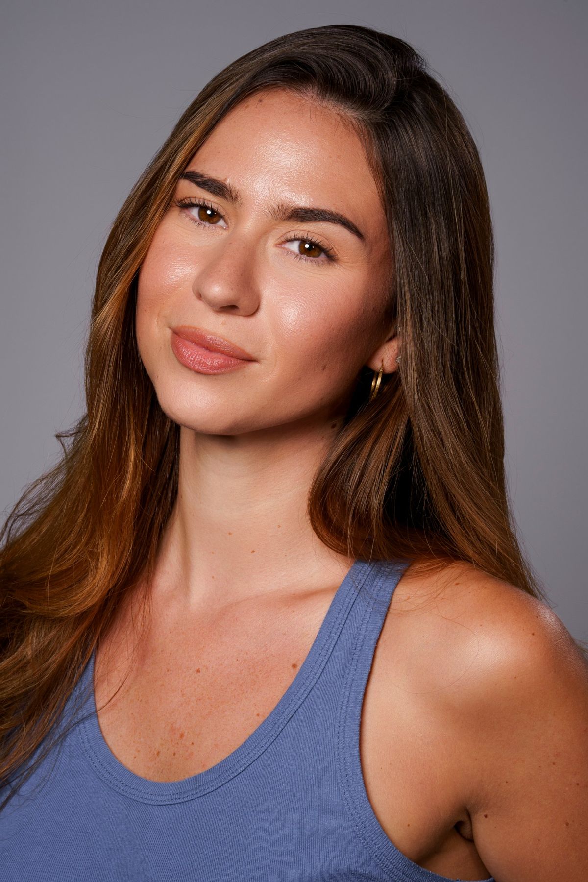 Headshot in blue tank top, soft smile