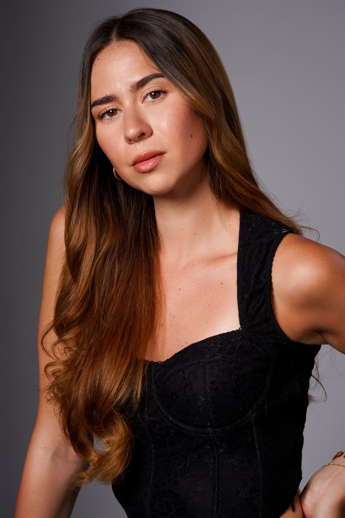 Headshot in black lace, hand on hip, head tilted