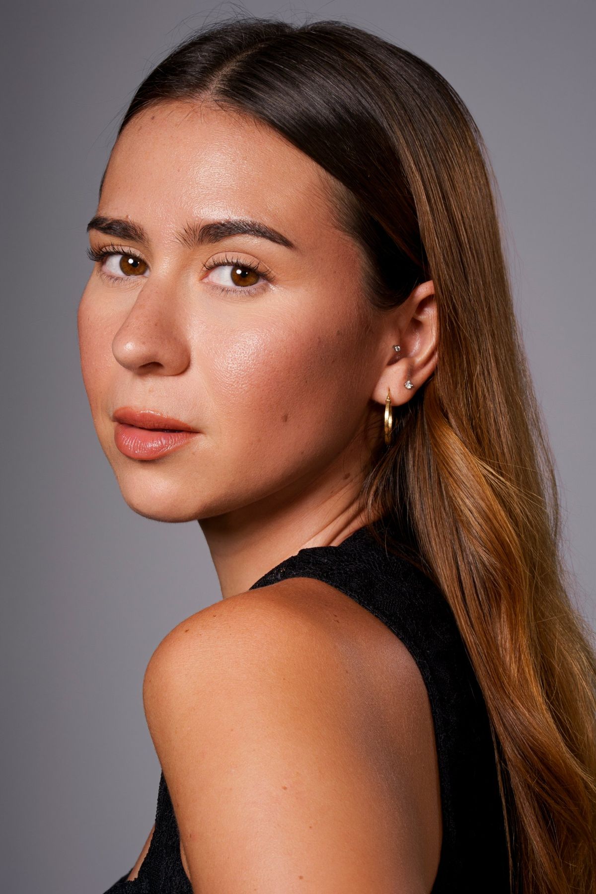 Headshot in black, looking back over the shoulder